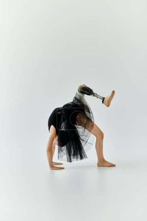 A young girl with a prosthetic leg performs a gymnastics pose, demonstrating incredible strength and agility.