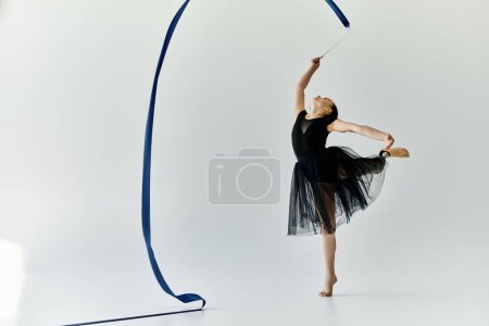 A young girl with a prosthetic leg performs a graceful gymnastics routine with a blue ribbon.