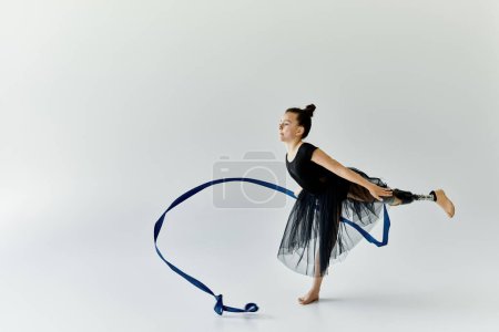 Ein junges Mädchen mit Beinprothese turnt anmutig mit blauem Band.