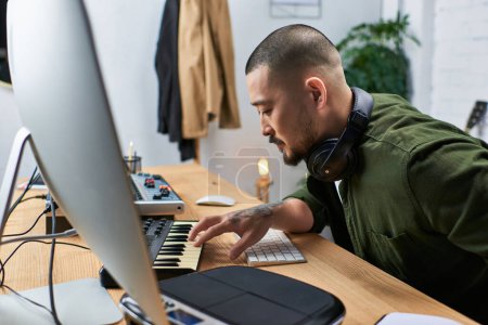 Un bel homme asiatique, multi-instrumentiste, est vu dans son atelier jouant du clavier.