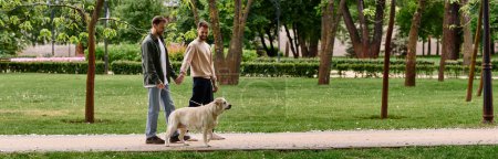 A bearded gay couple walks hand-in-hand with their labrador retriever through a lush green park on a sunny day.