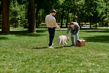 A gay couple with beards enjoys a sunny afternoon in a park with their labrador dog.