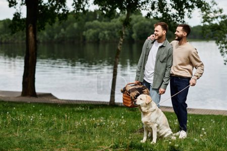 A bearded gay couple shares a loving moment with their labrador dog during a picnic in a green park near a lake.