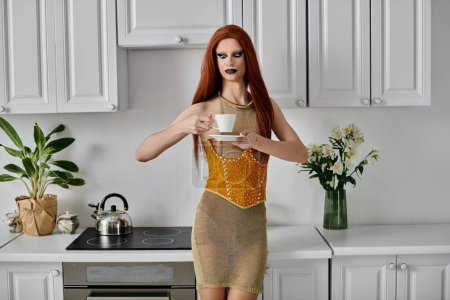 A drag diva in a sparkly dress enjoys a cup of tea in a pristine kitchen.