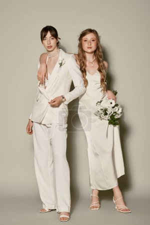 Foto de Dos mujeres vestidas de blanco posan para un retrato de boda, celebrando su amor y compromiso. - Imagen libre de derechos