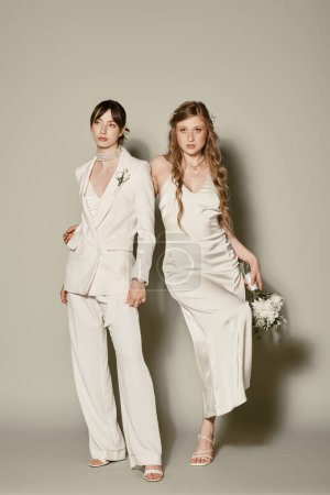 Dos novias, vestidas de blanco, permanecen juntas durante su ceremonia de boda.