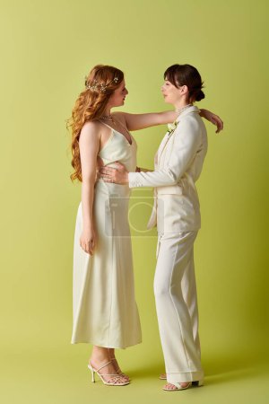 Zwei Bräute in weißem Brautkleid umarmen sich, ihre Liebe scheint durch auf grünem Hintergrund.