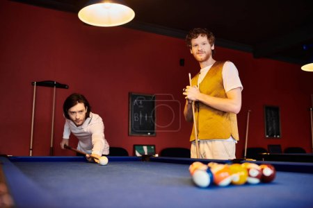 Friends play a casual game of billiards in a dimly lit room.