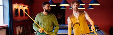 Friends play billiards in a dimly lit room with colorful lighting.