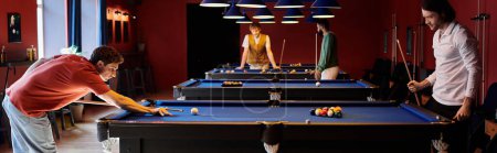 Friends play billiards in a dimly lit room, laughing and enjoying each others company.