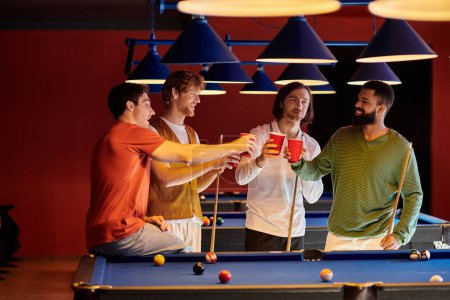 Friends enjoy a casual billiards game, raising red cups in a toast.