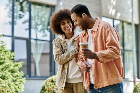 Ein glückliches Paar, ein afroamerikanischer Mann und eine afroamerikanische Frau, lächeln und bedienen sich der Zeichensprache, während sie draußen Kaffee trinken.