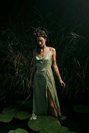 Eine Frau steht anmutig auf Lilienkissen in einem Sumpf, trägt ein fließendes grünes Kleid und eine florale Krone.