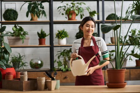Una mujer en un delantal riega una planta en su tienda de plantas, rodeada de varias zonas verdes.