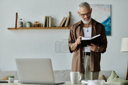 Un homme gay mature avec des tatouages et des cheveux gris travaille à distance de la maison, regardant concentré et heureux.