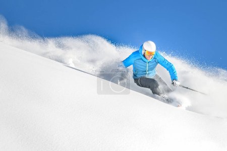 A skier on a carving turn in deep powder off-piste while free-riding