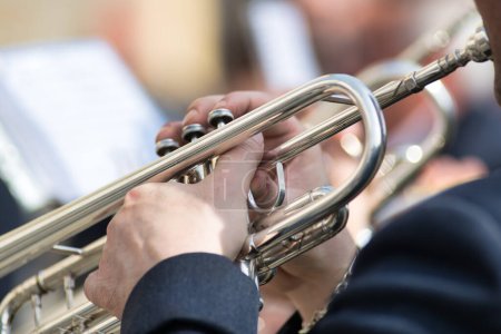 Details der Hände, die während eines Volksfestes in Norditalien Trompete spielen