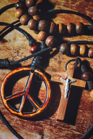Symbol of peace and the Crucifix on wooden table