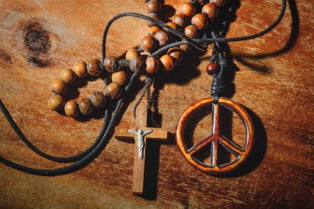 Symbol of peace and the Crucifix on wooden table
