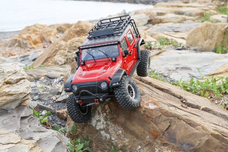 Radio controlled model car climbing on a rock.