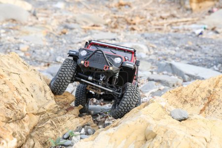 Photo for Radio controlled model car climbing on a rock. - Royalty Free Image