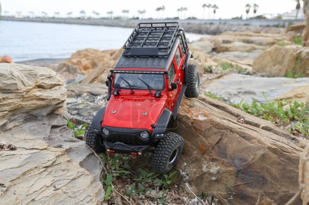 Radio controlled model car climbing on a rock.