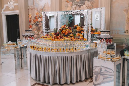 desserts with fruits, mousse, biscuits. Different types of sweet pastries, small colorful sweet cakes, macaron, and other desserts in the sweet buffet. candy bar for birthday. High quality photo
