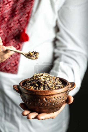 man holding bowl with traditional kutia, Christmas sweet dishes in Ukraine, Belarus and Poland. Christmas dinner kutia.