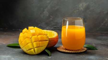 Photo for Mango juice. Fresh tropical fruit smoothie on a dark background. Long banner format. - Royalty Free Image