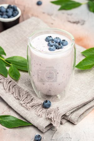 Photo for Blueberry jogurt, Tasty blueberry smoothie in glass on a light background, vertical image. place for text, - Royalty Free Image