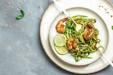 Photo for Pasta spaghetti zucchini basil pesto sauce and grilled shrimp, Vegetarian vegetable pasta, Food recipe background. Close up, - Royalty Free Image