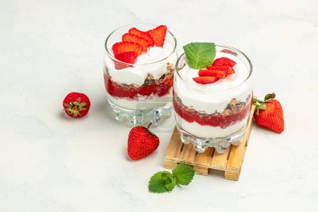 Photo for Parfait with yogurt, granola, jam, fresh berries and mint leaves in glass jar. gluten free diet, Healthy breakfast. banner, menu, recipe place for text, - Royalty Free Image