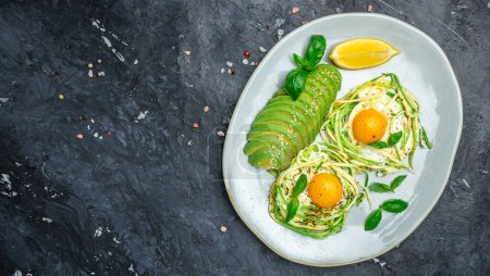 Plate with a keto diet food. paleo keto breakfast fried eggs, zucchini and avocado. Keto, paleo breakfast. Top view, copy space.