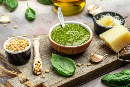 Téléchargez les photos : Pesto, Italian basil pesto sauce with culinary ingredients for cooking on a light background, banner, menu, recipe place for text, top view, - en image libre de droit