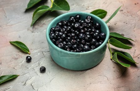 Superfoods antioxidant of indian mapuche. Bowl of fresh maqui berry on light background, top view.