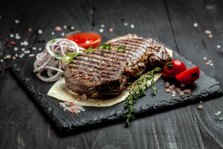 Foto de Filete de ternera a la parrilla. Barbacoa seca Ribeye Steak sobre fondo de madera. vista superior, - Imagen libre de derechos