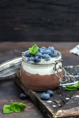Köstliche Schokoladenmousse oder Pudding mit Schlagsahne. Schokoladenpanna cotta mit Blaubeeren. Schokoladenpudding und griechisches Joghurt-Parfait.