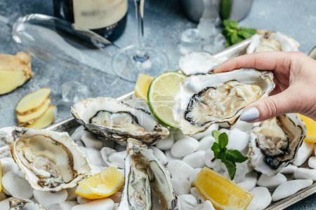 Photo for Fresh oysters on ice with lemon. Healthy food, gourmet food. Oyster dinner in restaurant. - Royalty Free Image