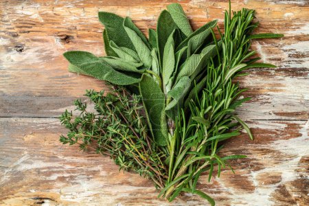 Fresh garden herbs rosemary, thyme and sage on a wooden background, banner, menu, recipe place for text, top view