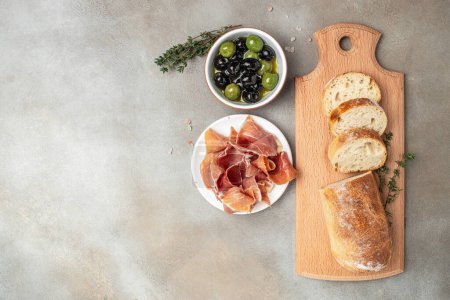 Photo for Delicious appetiser Italian prosciutto and Spanish Iberian ham snack bread ciabatta and olives. banner, menu, recipe place for text, top view. - Royalty Free Image