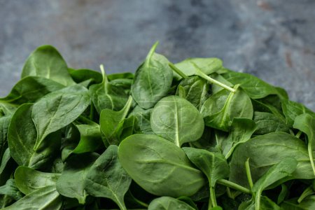 Fresh green spinach. Healthy leafy vegetables on the table. Food recipe background. Close up.