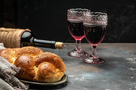 Shabbat Shalom challah bread, shabbat wine on a dark background, place for text, top view,