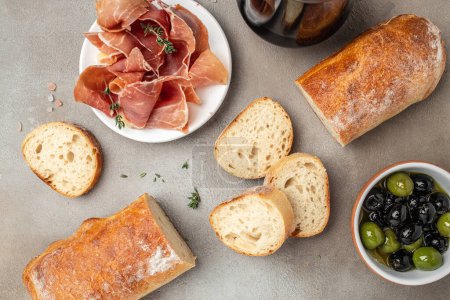 Photo for Delicious appetiser Italian prosciutto and Spanish Iberian ham snack bread ciabatta and olives. banner, menu, recipe place for text, top view. - Royalty Free Image