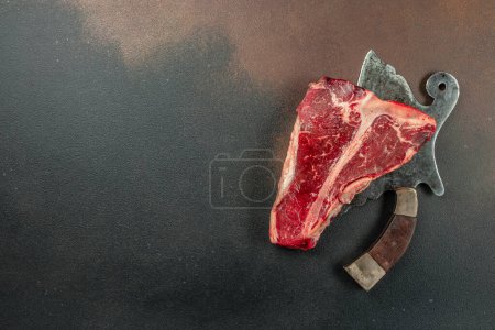 Photo for Meat Steaks T-bone between knife, on black stone background. Raw beef meat. place for text, top view. - Royalty Free Image