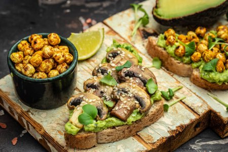 Photo for Mashed avocado, mushrooms and chickpea toasts. Delicious breakfast or snack, Clean eating, dieting, vegan food concept. top view. - Royalty Free Image