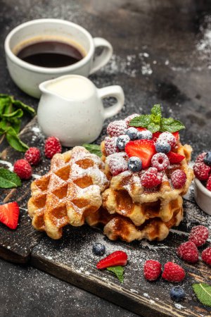 Photo for Belgian waffles with raspberries with sugar powder in a freeze motion of a cloud of powder midair, served with jug of milk. Delicious breakfast or snack. - Royalty Free Image