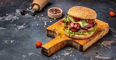 Photo for Craft beef burger with cheddar, lettuce and sauce on a wooden board, Hamburger. Fast food concept. - Royalty Free Image