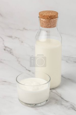Téléchargez les photos : A bottle of milk and glass of yogurt, kefir, fermented milk, Probiotic cold fermented dairy drink. top view, - en image libre de droit