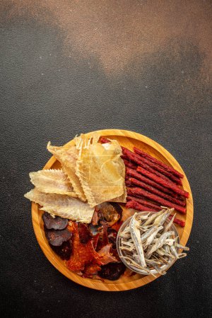 Photo for Variety of dried fish, snacks for beer on a dark background. vertical image. top view. place for text. - Royalty Free Image