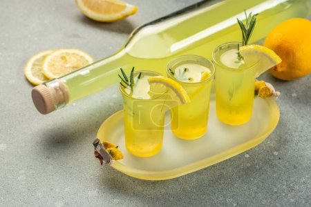 Photo for Italian lemon liqueur limoncello in small glasses and bottle. Italian alcoholic drink. place for text. - Royalty Free Image